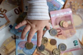 Foto: Geld und eine Baby-Hand